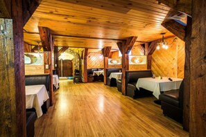 A restaurant with wooden floors and walls, booths, and tables.