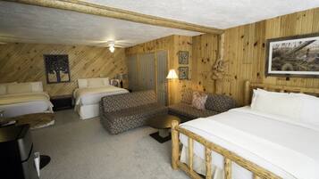 Una habitación acogedora con una cama grande, dos camas individuales, un sofá y un escritorio.
