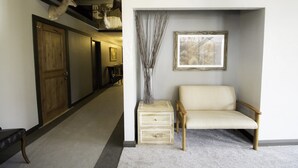 A hallway with a wooden bench, a vase with branches, and a framed picture on the wall. - Colter's Lodge (Afton)