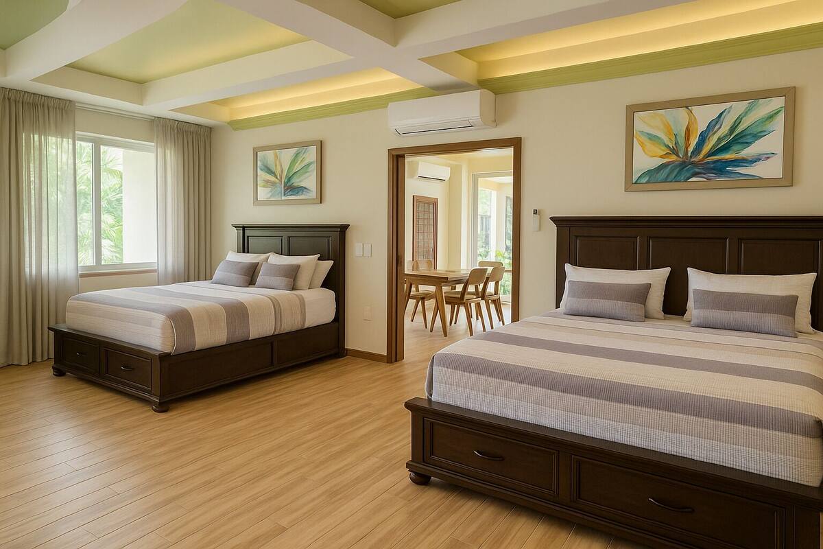 Habitación de hotel con dos camas, una zona de comedor y obras de arte en las paredes.