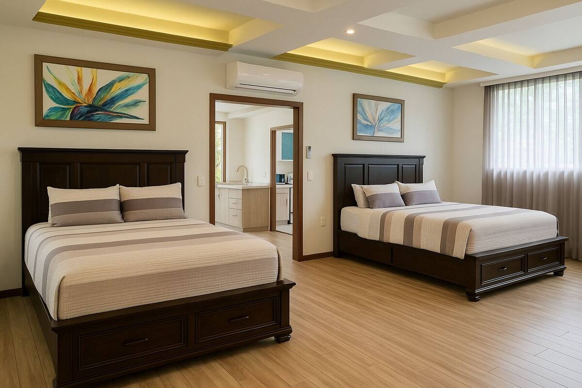 Habitación de hotel con dos camas, baño y obras de arte en las paredes.