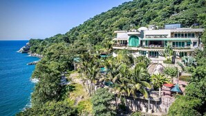A coastal property with a large building, lush greenery, and a view of the ocean. - Villa Armonia Boutique (Puerto Vallarta)