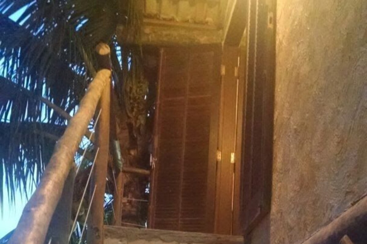 A wooden staircase with a glass balustrade leading to a wooden door.