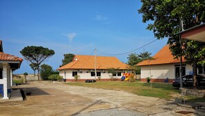 A residential area with two houses, a playground, and a paved road. - Marang Village Resort & Spa (Marang)