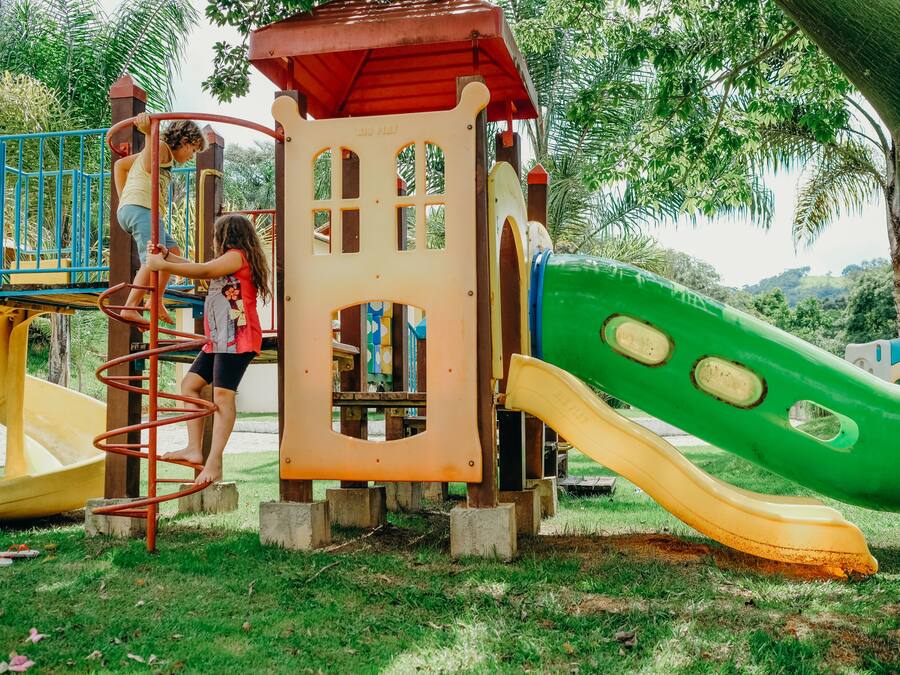 A playground with a spiral slide, a yellow slide, and a green slide.