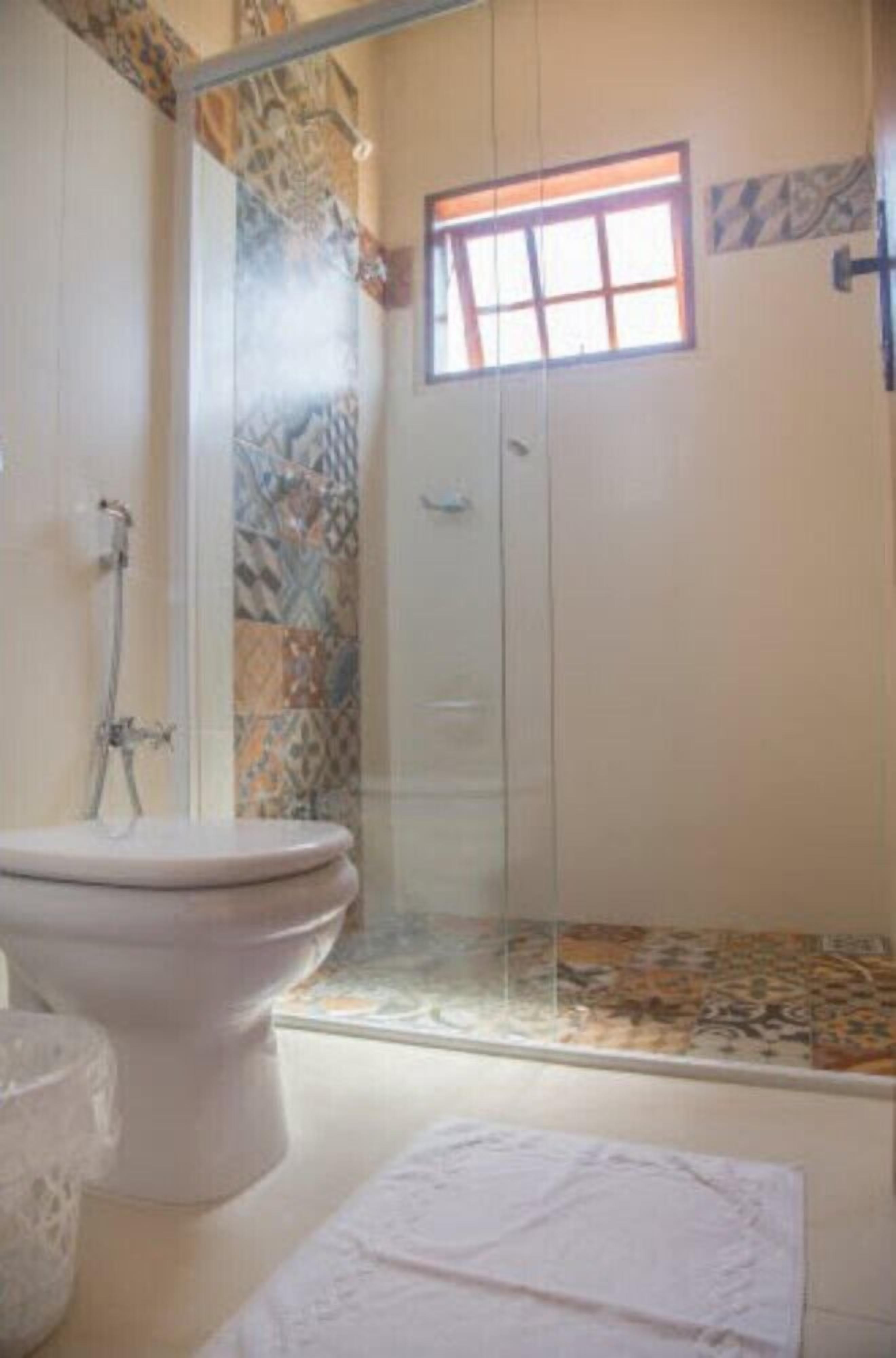 Un baño con ducha, inodoro y ventana.