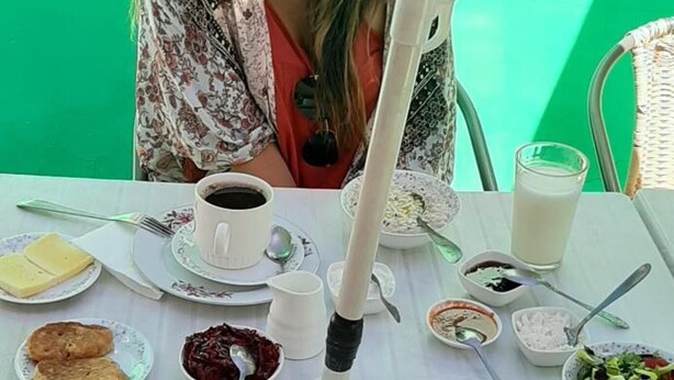A table set with breakfast items including toast, fruit, and a salad. - Guest House Nise (Tbilisi)