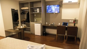 A hotel room with a bed, a desk with a laptop, a TV, a microwave, and a mini-fridge. - Hotel Dom Rafael Premium (Santa Maria)