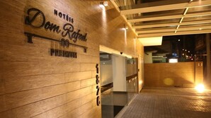 A hotel entrance with a wooden facade and a glass door. - Hotel Dom Rafael Premium (Santa Maria)