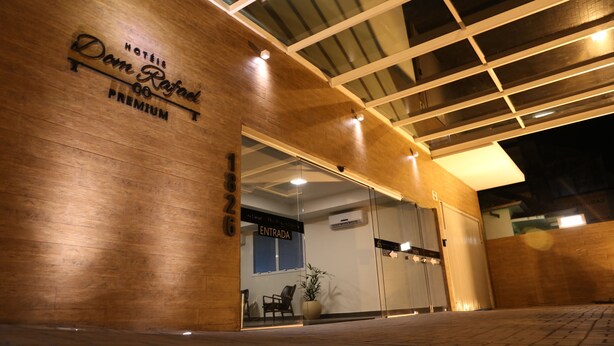 A hotel entrance with a wooden facade, a glass door, and a sign indicating "HOTEL Dom Rafael PREMIUM." - Hotel Dom Rafael Premium (Santa Maria)