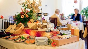 A buffet table with various food items and a decorative centerpiece. - Hotel Birkenstern (Bad Wildungen)