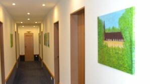 A long, narrow hallway with carpeted floors, wooden doors, and recessed lighting. - Hotel Birkenstern (Bad Wildungen)