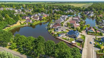 Zona residencial con casas a lo largo de un río, rodeada de vegetación.