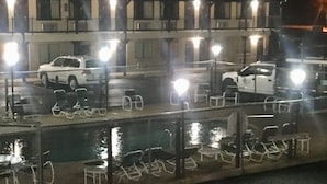 A nighttime view of a waterfront area with a docked white truck and several chairs. - Inn At Mexia (Mexia)