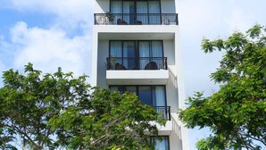 Un immeuble à plusieurs étages, doté de balcons et de fenêtres, portant l’inscription « SON TRA GREEN ».
