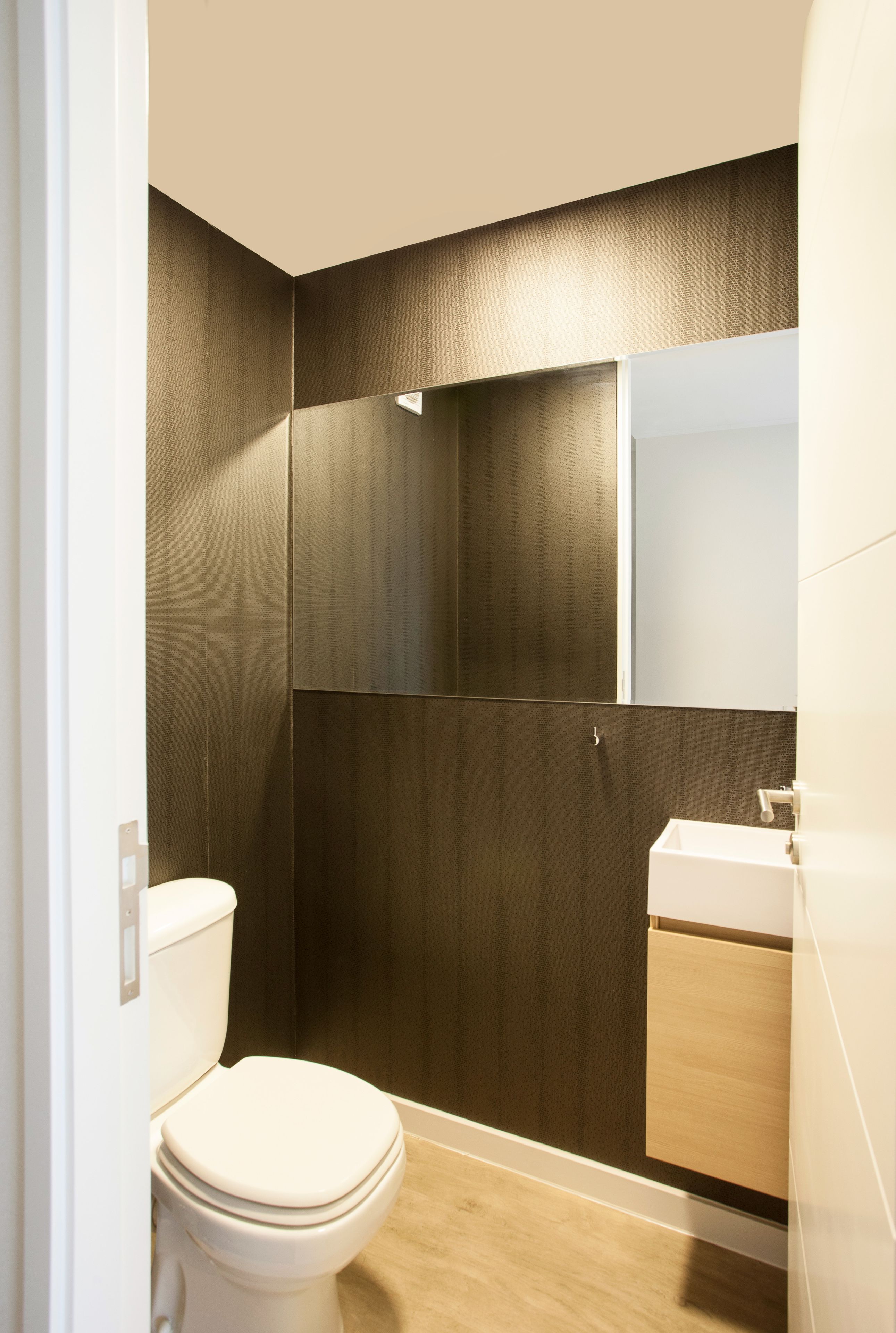 A modern bathroom with a toilet, a shower, and a sink.