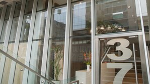 Un edificio moderno con amplios ventanales y una escalera que conduce a una entrada.
