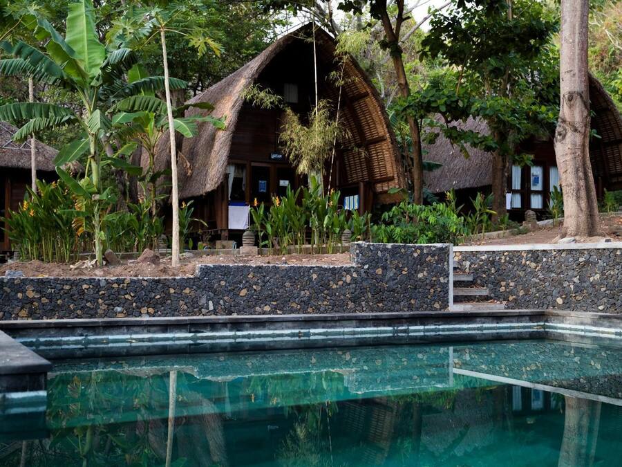 Una piscina al aire libre, sillones reclinables de piscina