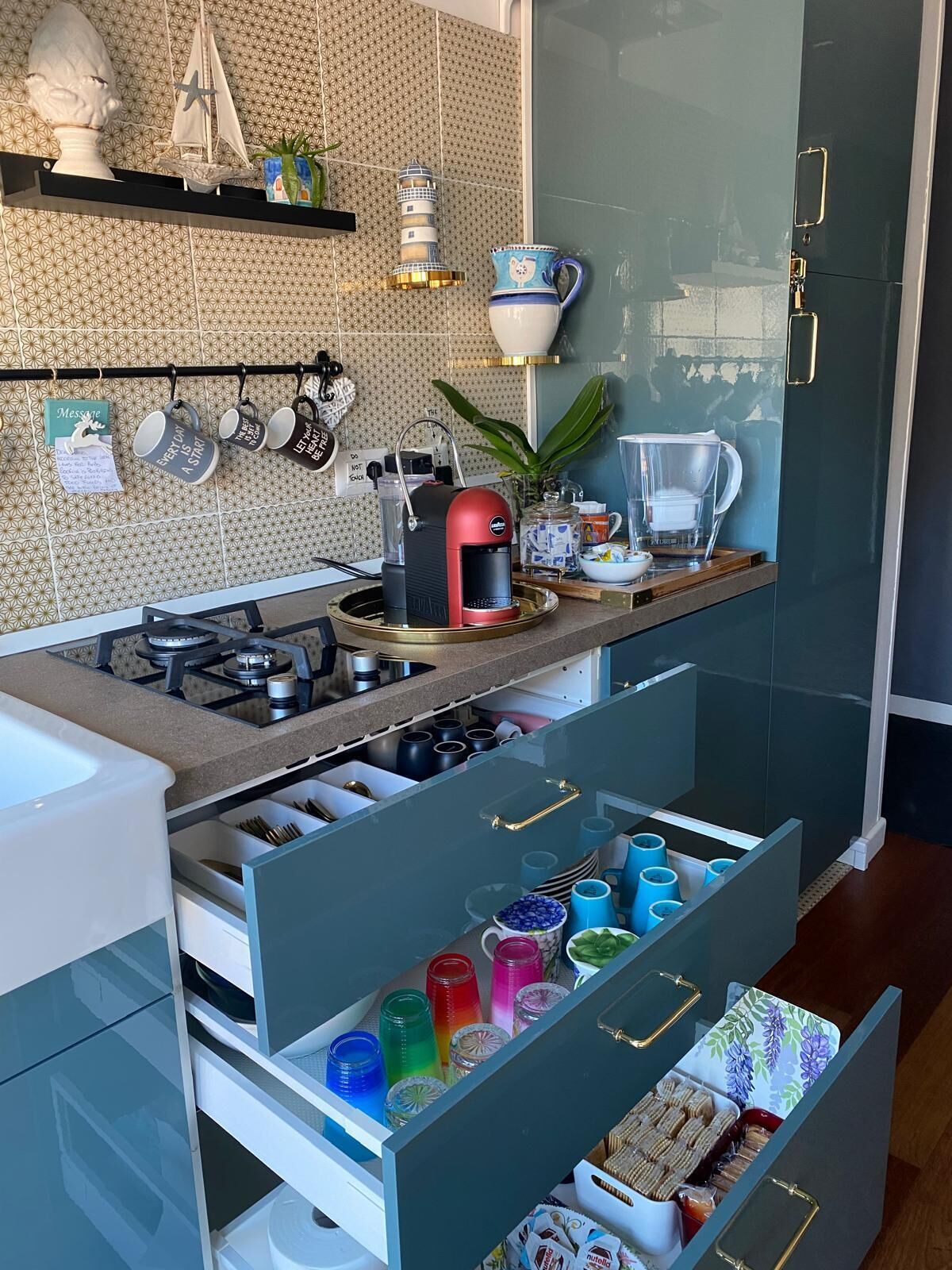 Una cocina moderna con cafetera, hervidor y diversos utensilios de cocina.