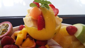 Ensalada de frutas con una variedad de frutas, incluyendo mango, fresas y kiwi.