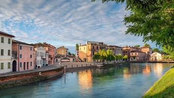 Un canale con edifici su entrambe le rive, un ponte e cielo sereno.