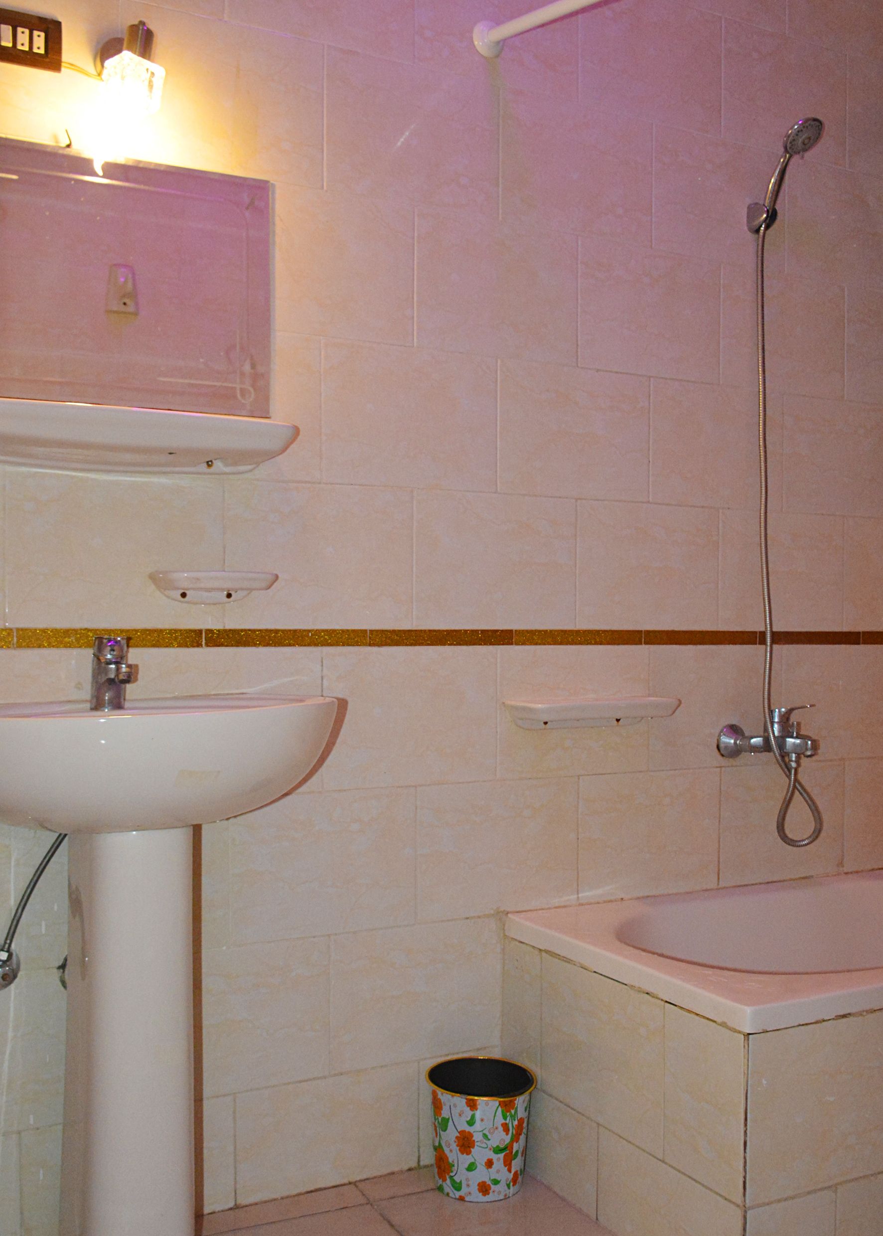 Ein Badezimmer mit Waschbecken, Spiegel, Dusche und Toilette.
