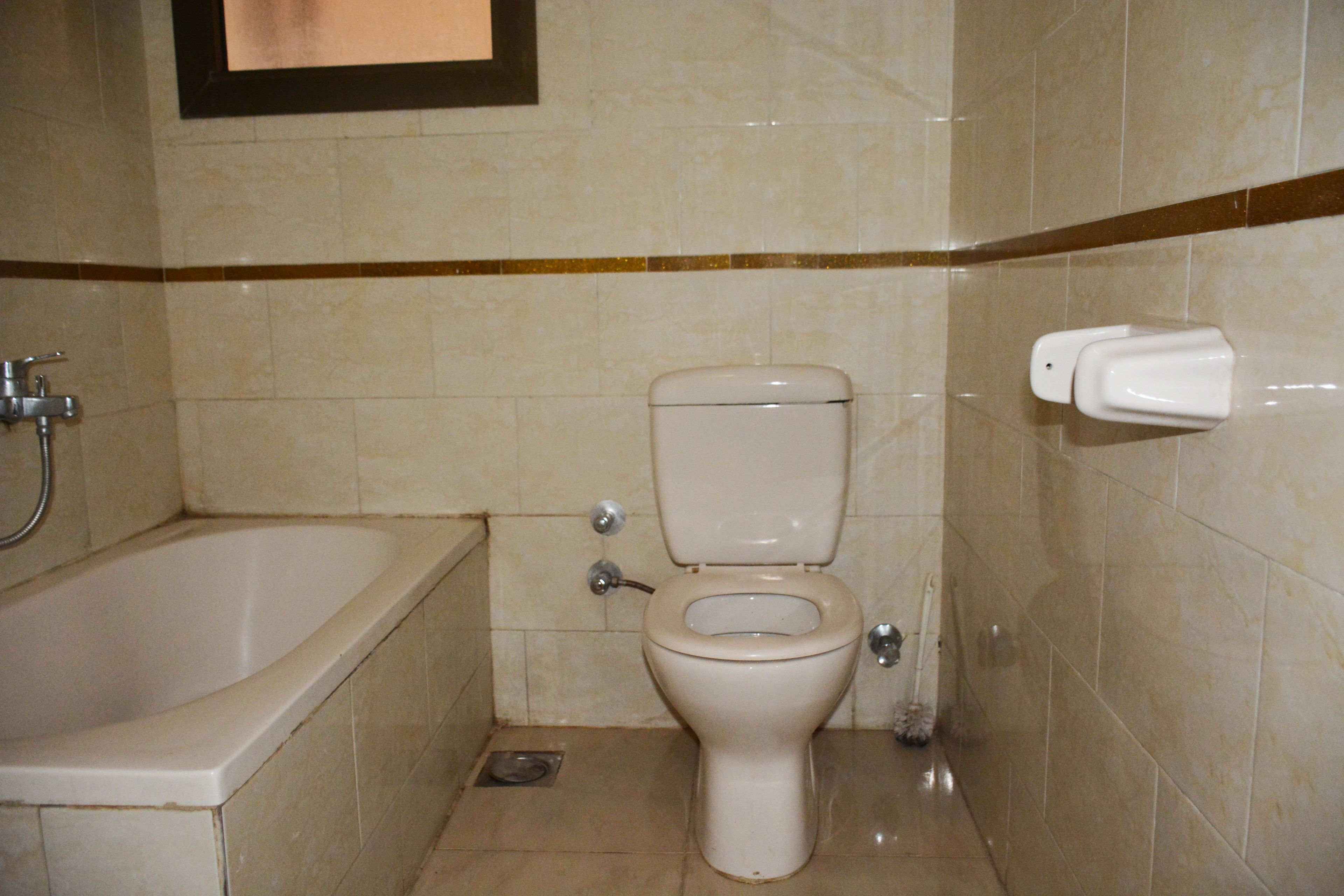 A bathroom with a toilet, a bathtub, and a hand dryer.
