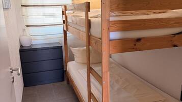 Un letto a castello con una finestra e un piccolo ripiano.