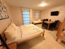 A bedroom with a bed, a desk, and a chair.
