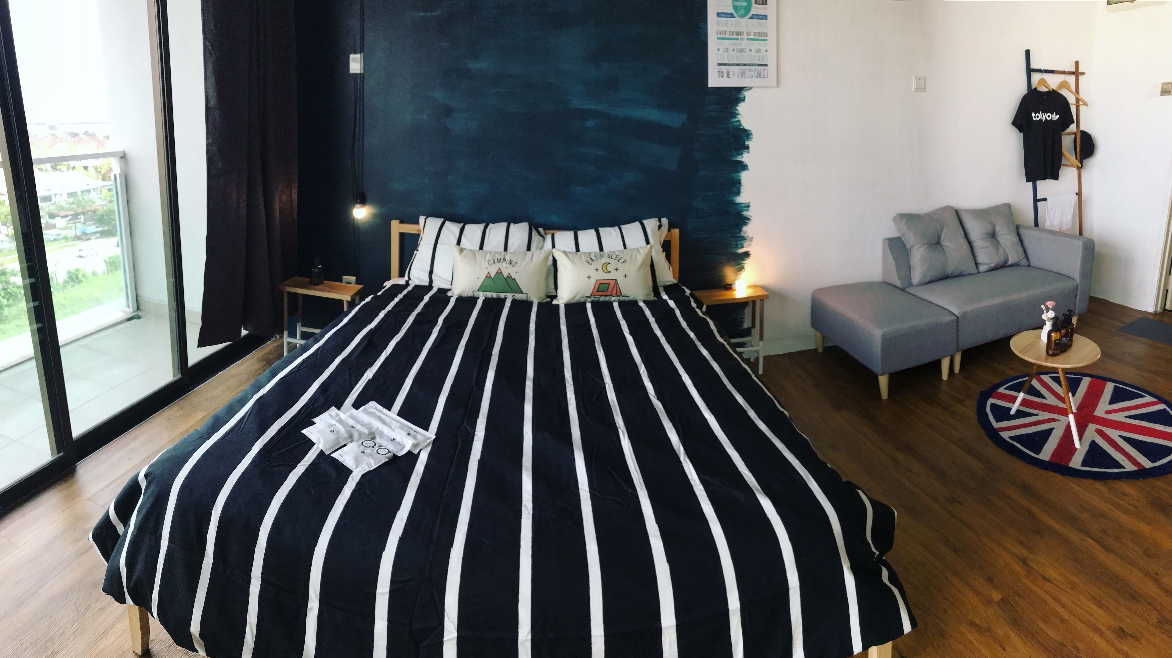 Un dormitorio con una cama grande, un sofá, una mesita y vistas al exterior.
