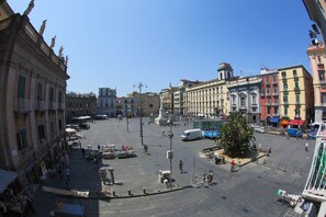 A spacious public square with historical buildings, a central monument, and a small tree. - The Dante House (Naples)