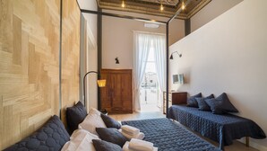 Quarto moderno com uma cama grande, uma cama menor e um guarda-roupa de madeira.