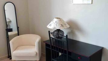 A room with a desk, chair, and a small sofa.