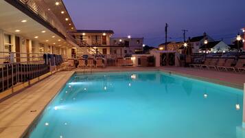 Una piscina al aire libre de temporada, sombrillas