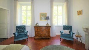 A room with two blue armchairs, a wooden cabinet, and a painting on the wall. - Maison De L'Aguze (Saint-Pons-de-Thomieres)
