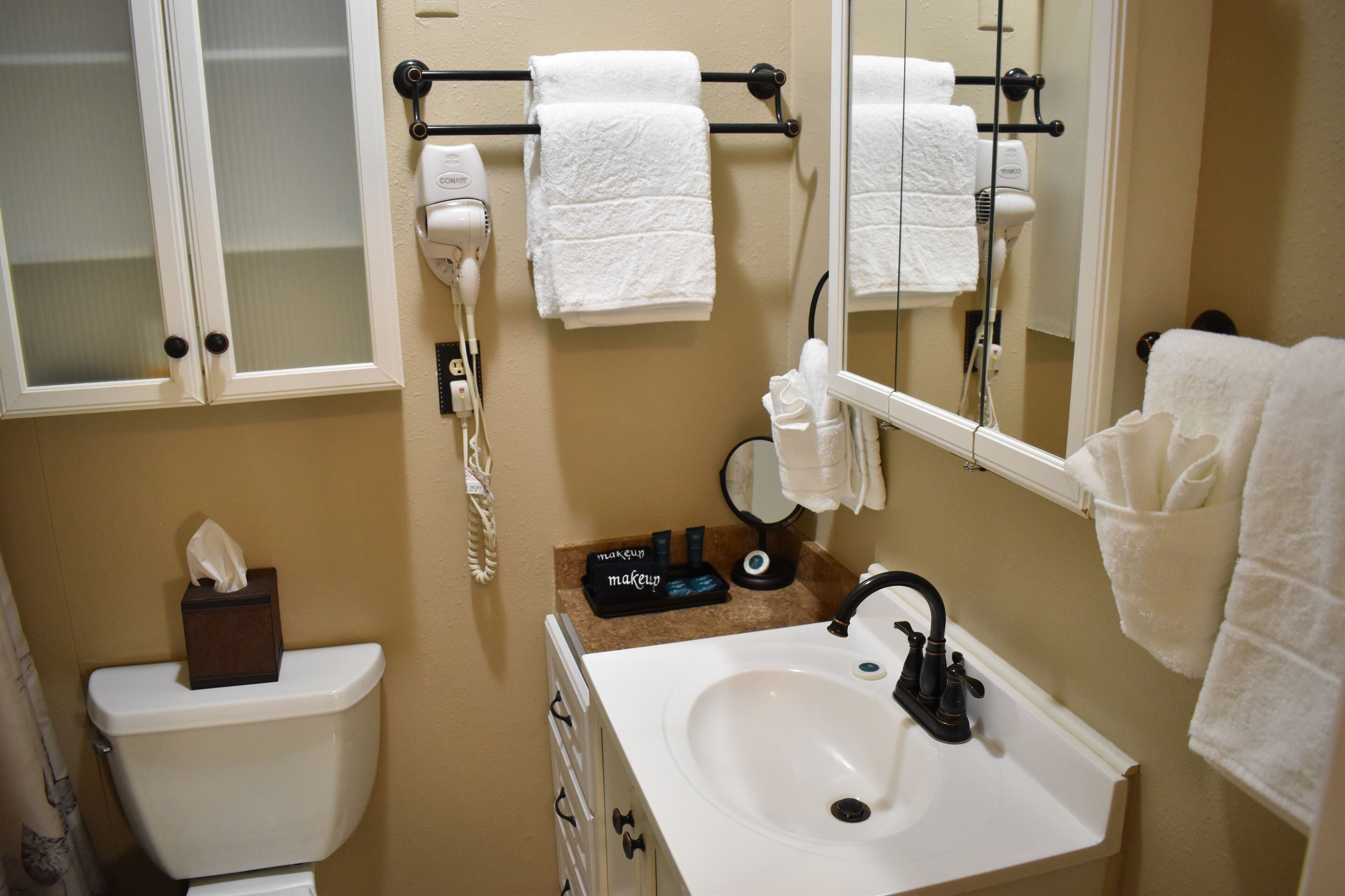A bathroom with a toilet, sink, and towel rack.