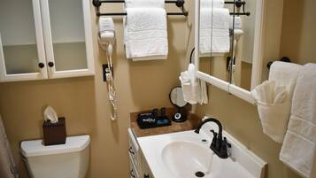 A bathroom with a toilet, sink, and towel rack.
