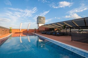 Et poolområde på taget med liggestole og frit udsyn til hotelskiltene.