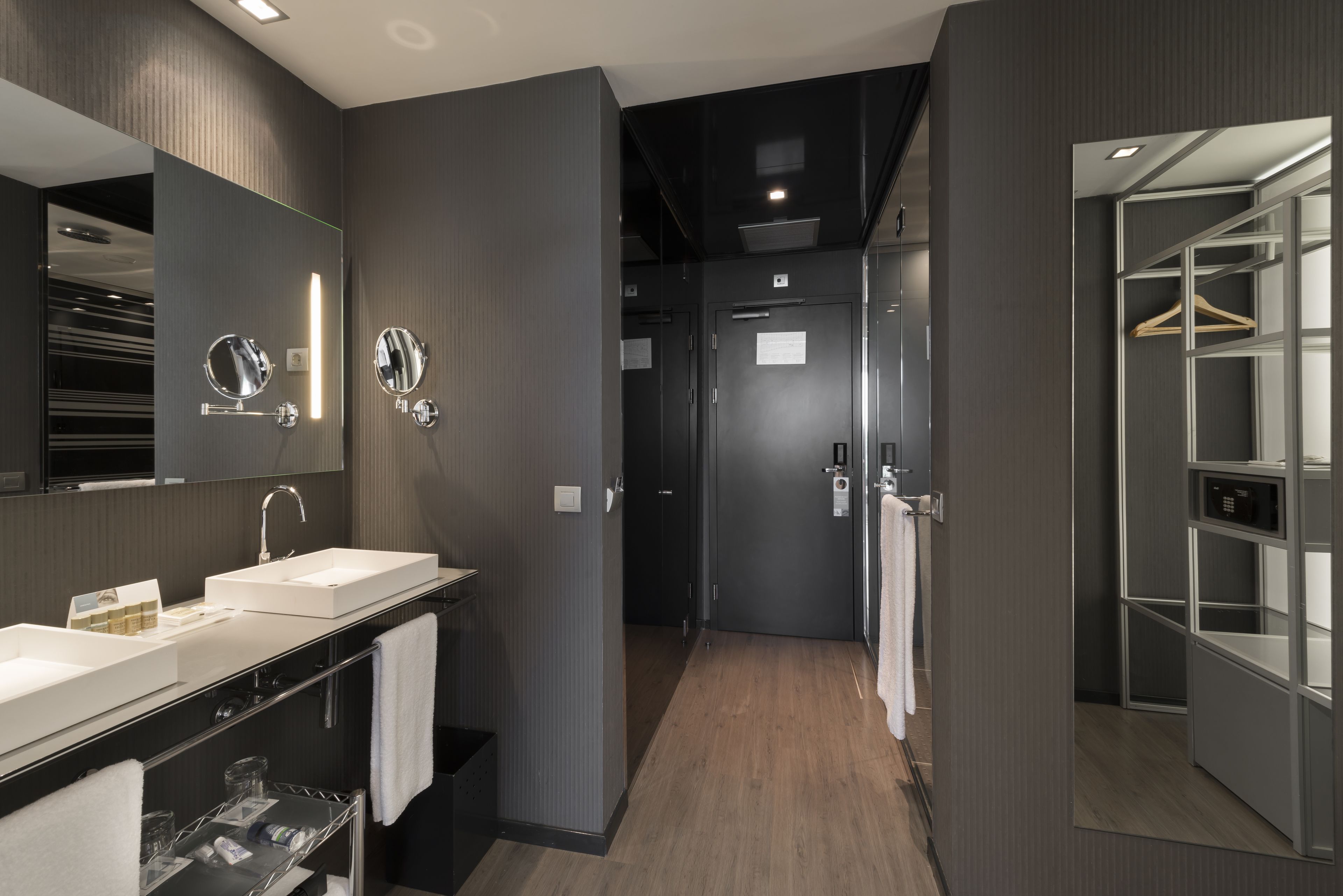 Une salle de bain moderne avec deux lavabos, un grand miroir et une douche à l’italienne.