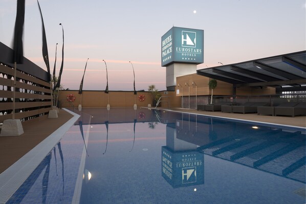 A hotel pool area with a clear view of the pool, lounge chairs, and a sign for the Eurostars Hotels.
