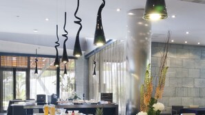 Un bufé con diversos alimentos y un interior moderno con lámparas colgantes.