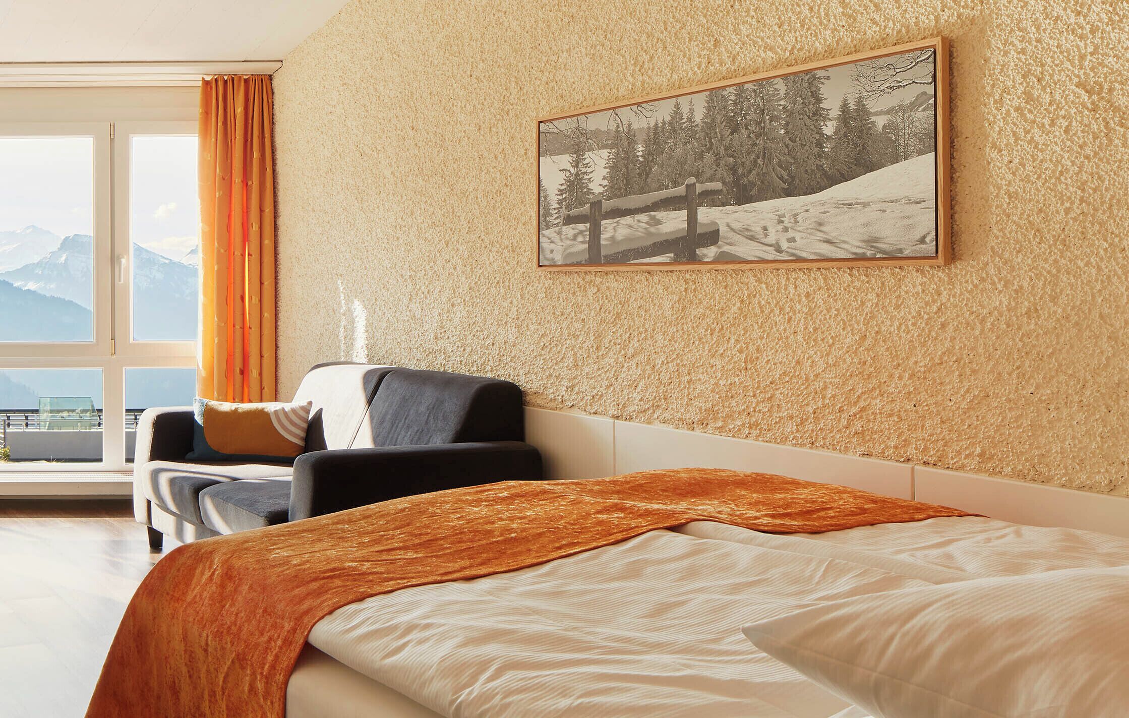 Habitación de hotel con cama, una silla, ventana con cortinas e imagen enmarcada en la pared.