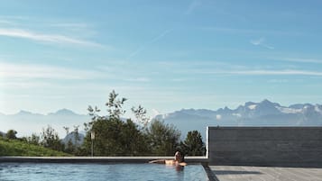 Een binnenzwembad, een buitenzwembad, ligstoelen bij het zwembad