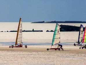 Una playa con tres tablas de vela.