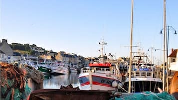 A harbor with boats docked, fishing nets, and a clear sky.