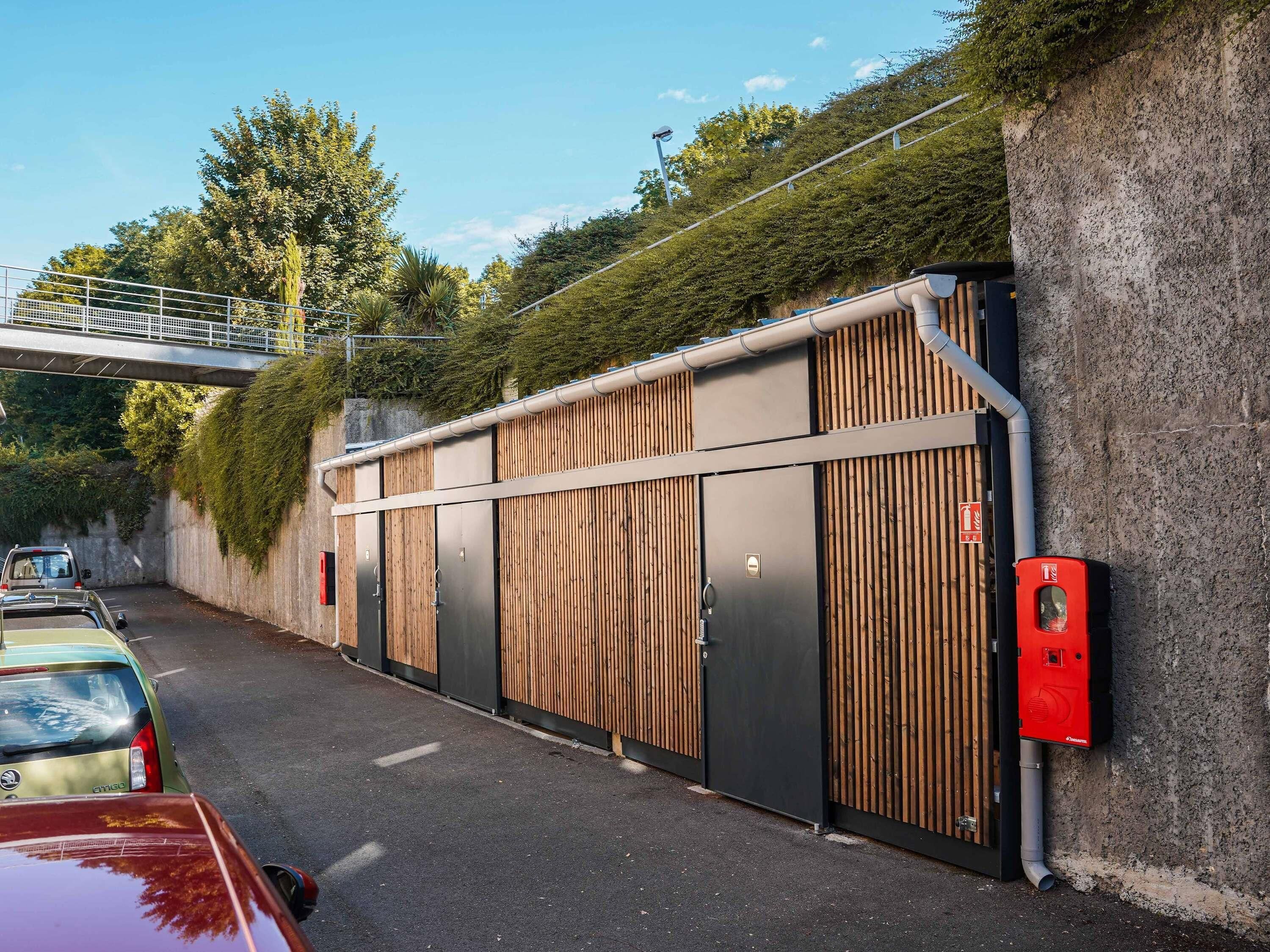 A parking garage with a modern design, featuring a covered walkway and a gated entrance.