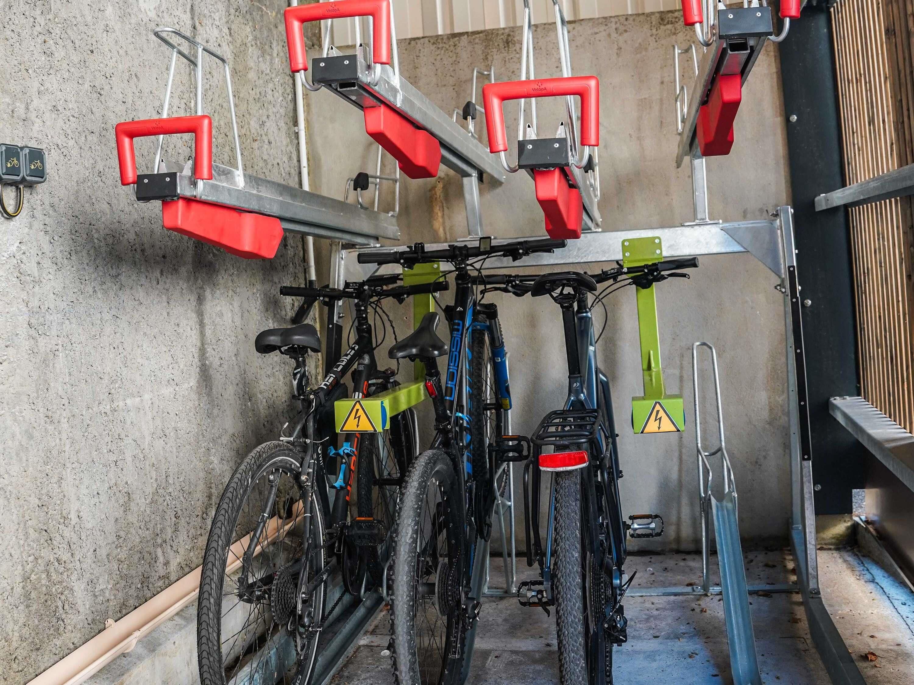 Un'area di parcheggio per biciclette con diverse bici fissate a un supporto metallico.