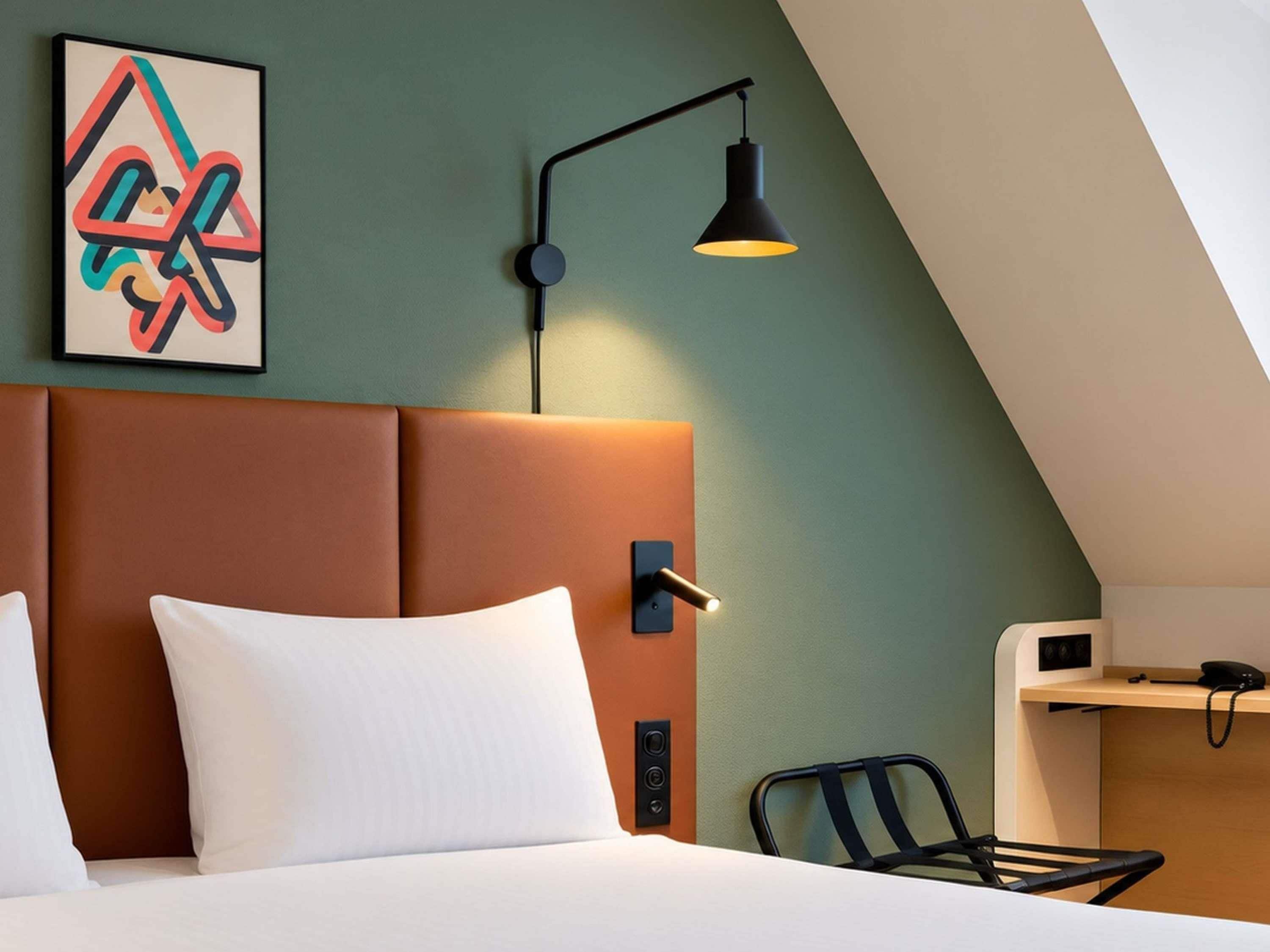 Una habitación de hotel moderna con una cama, un escritorio y una silla.