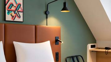 Una habitación de hotel moderna con una cama, un escritorio y una silla.