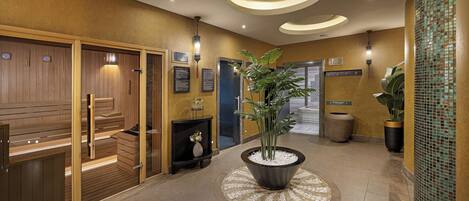 A lobby with wooden paneling, a central potted plant, and a tiled floor.